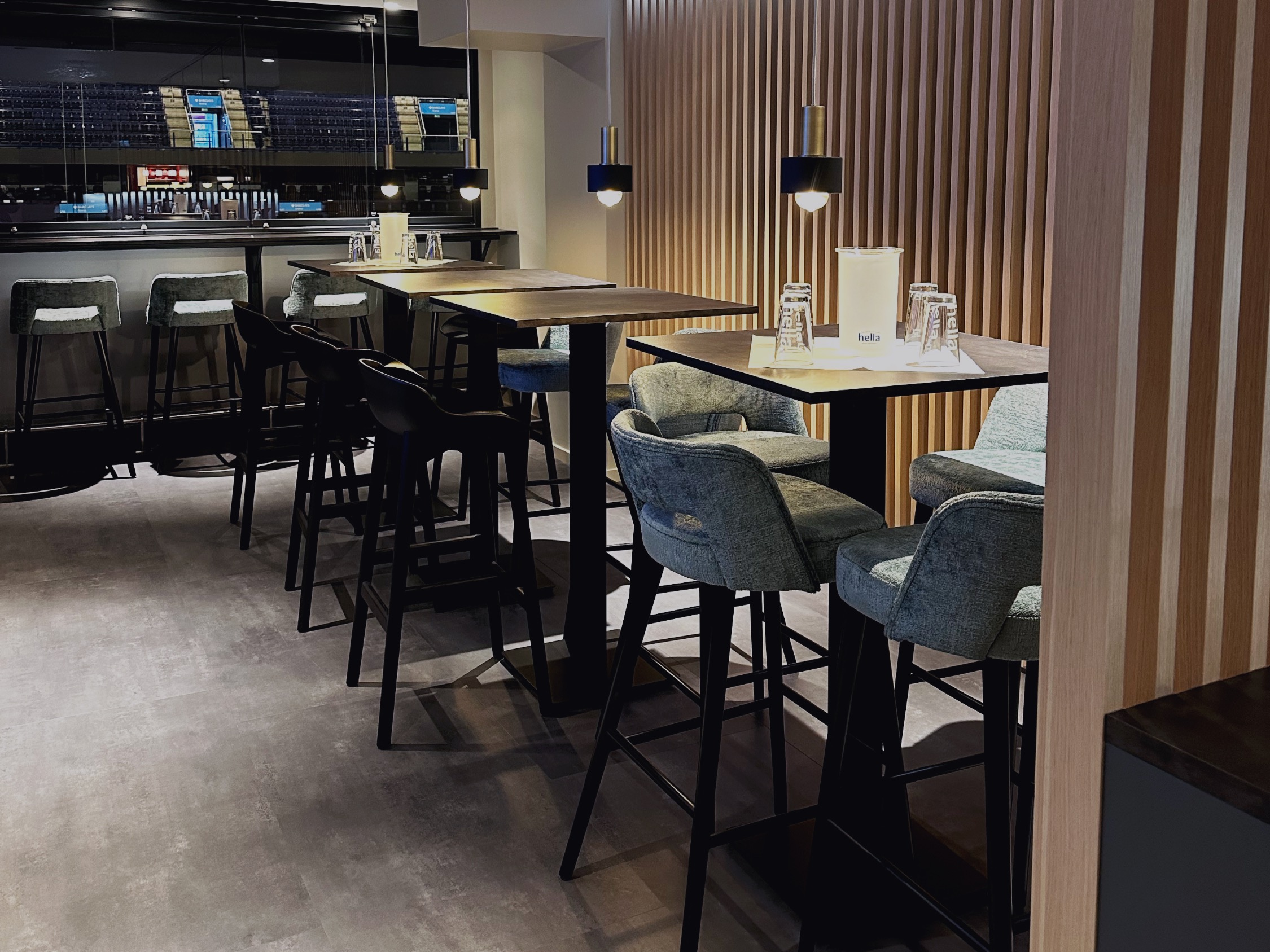 Modernisierte Arena-Loge mit Holzlamellen, maßgefertigten Tischen und Blick auf den Innenraum